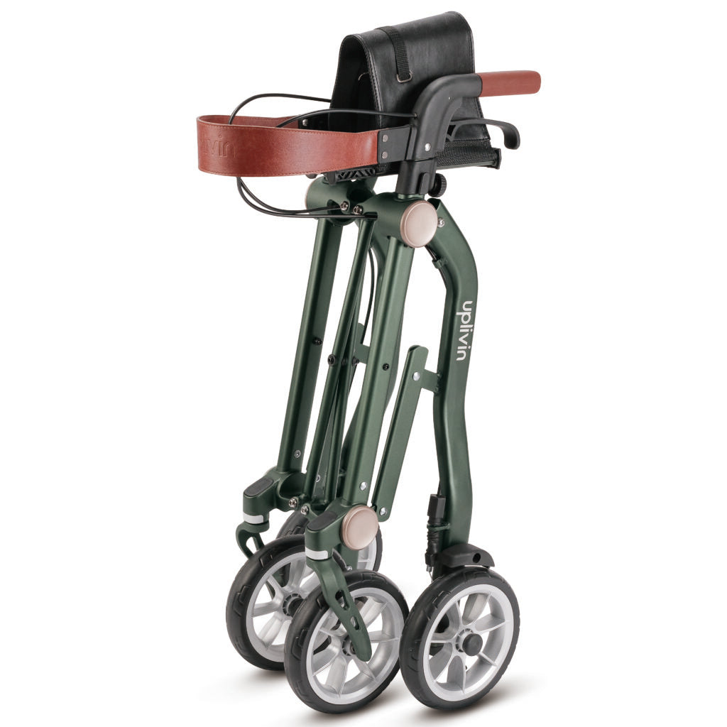 De Trive Rollator opgevouwen en afgebeeld op een witte achtergrond. Een lichtgewicht en compacte loopwagen met vier wielen, handremmen en een zitje. Eenvoudig op te bergen en mee te nemen, ideaal voor mensen die onderweg extra ondersteuning nodig hebben bij het lopen.